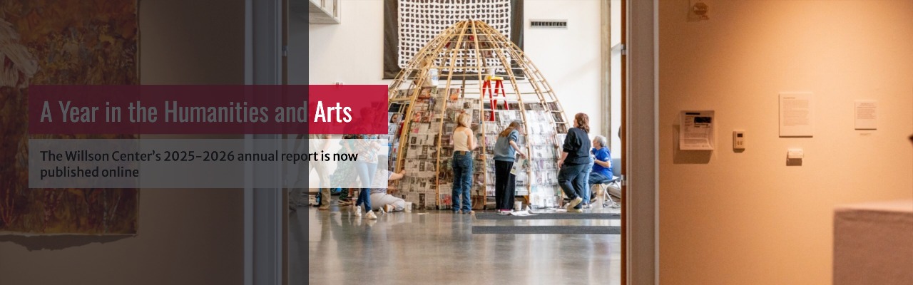 People are gathered around a partially constructed wooden dome structure in an art gallery, with informational text overlaid on the left side of the image.